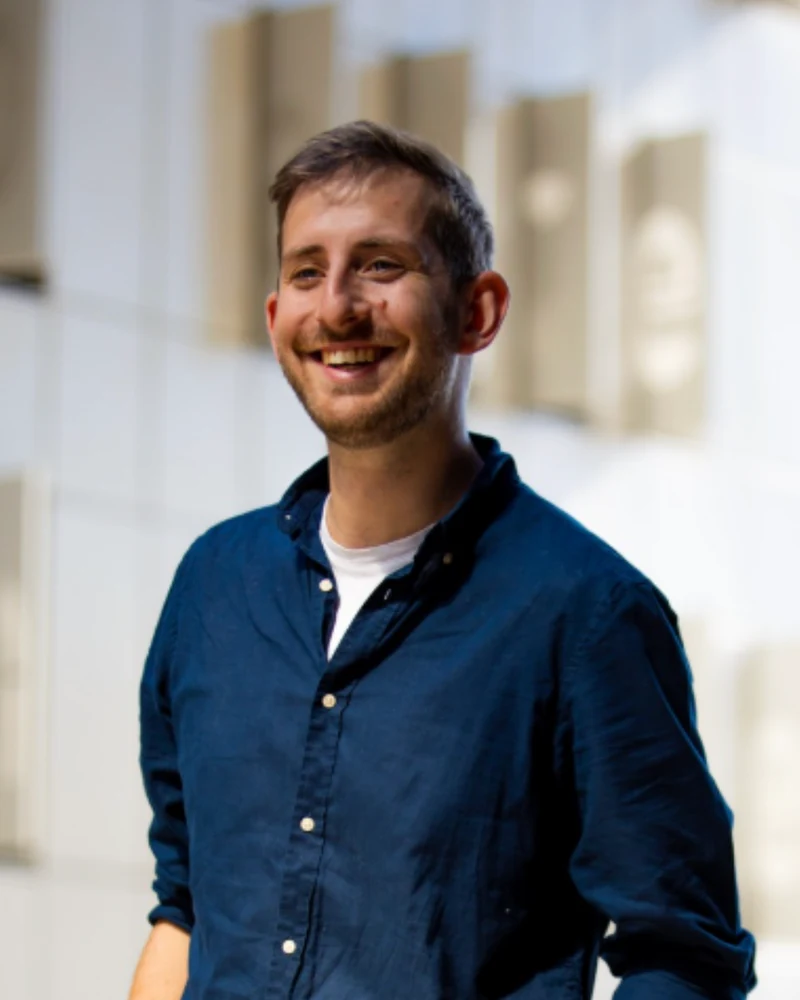 Portrait de Guillaume, souriant, en chemise bleu marine