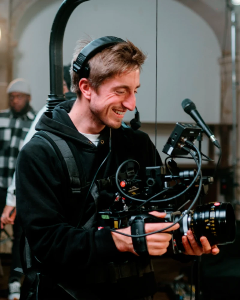 Portrait de Martin, casque audio sur les oreilles, derrière sa caméra